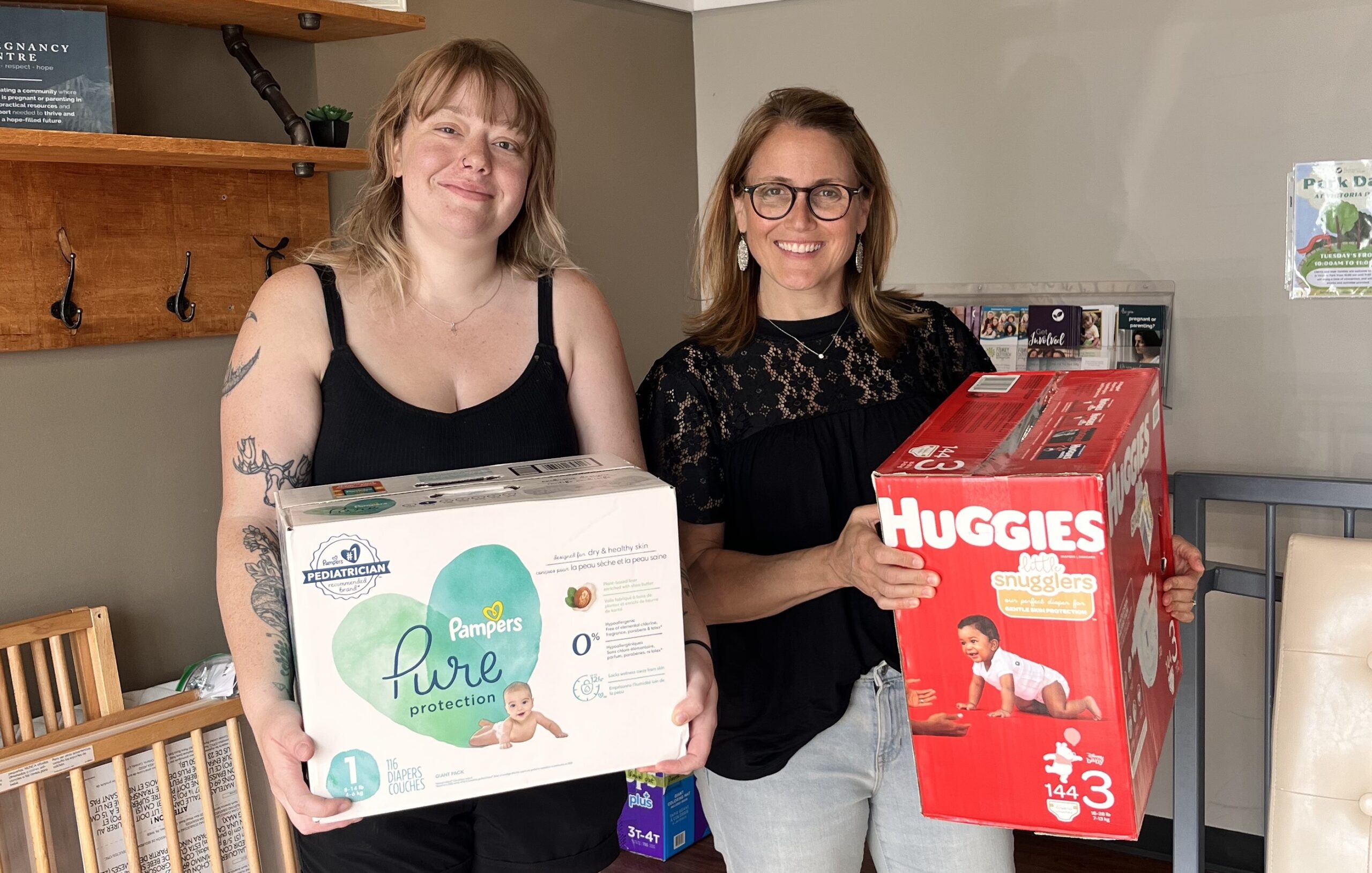 two women pose with a diaper donation