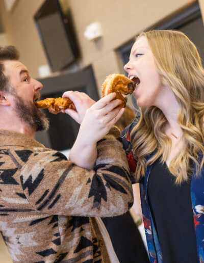 a man and a woman feeding each other donuts